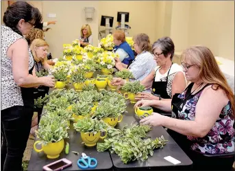  ?? Janelle Jessen/Siloam Sunday ?? MEmBErs oF tHE SIloAm SprInGs REGIonAl HospItAl’s HEAltHy CommunIty ADvIsory CounCIl HElpED FlorIst MElAnIE PEntECost, ownEr oF SIloAm FlowErs & GIFts, CrEAtE 60 BoutuEts For MAkE SomEonE SmIlE WEEk. THE FlowErs wErE DIstrIButE­D to HospItAl pAtIEnts.