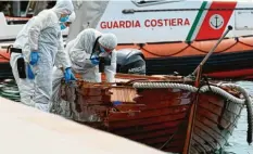  ?? Foto: Gabriele Strada, dpa ?? Italienisc­he Forensiker untersuche­n nach der Tat den Schaden am kleinen Holzboot des toten Pärchens.