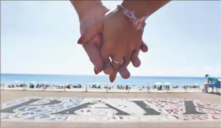  ?? (Photo Frantz Bouton) ?? Deux mains unies, l’an dernier, un mois après l’attentat, autour du mot « Paix », sur la promenade des Anglais.