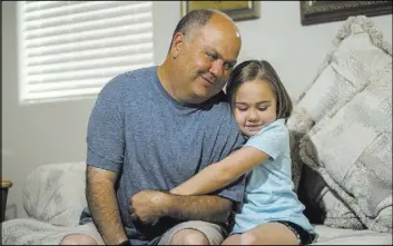  ?? MARTIN S. FUENTES/VIEW ?? Peter Kohler poses with his daughter Alexa, 8, at their Summerlin-area home on May 27. Kohler and his daughter have a strong bond, even stronger after Alexa was diagnosed with medullobla­stoma, a fast-growing, high-grade cancerous brain tumor, at age 4.