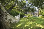  ?? ERIC LAIGNEL ?? This photo provided by Rottet Studio shows a backyard designed by architect and interior designer Lauren Rottet in Montauk, N.Y. Adding a cozy hammock as Rottet did in this backyard, brings beauty and comfort and can be especially useful if you’re staying home for much of this summer.