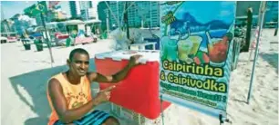  ??  ?? File photo shows Caipirinha vendor Vanderclei Silva Santos, who says he struggles to communicat­e with foreign tourists, poses for a portrait at his stand on Copacabana beach in Rio de Janeiro, Brazil.