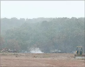  ?? Keith Bryant/The Weekly Vista ?? A mixture of steam and smoke rises from the smoldering stump dump off Trafalgar Road during a rain storm.