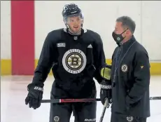  ?? NANCY LANE / BOSTON HERALD ?? Bruins defenseman Jeremy Lauzon talks with coach Bruce Cassidy on Thursday at Warrior Ice Arena in Brighton.