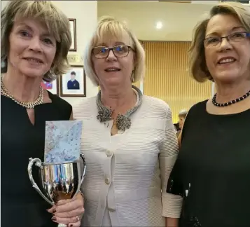  ??  ?? Joan Bowe receives the Rosslare lady golfer of the year trophy from sponsor Eleanor Wardlaw in the presence of lady Captain Niamh Byrne.