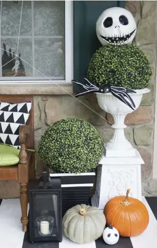  ??  ?? The Jack Skellingto­n head was placed on a plant for the neighborho­od children and complement­s the black-and-white theme of the porch. “My husband has worn it every year while he sits on the porch to hand out candy,” says Julia. “One year he had to work...