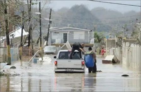  ?? CARLOS GIUSTI — THE ASSOCIATED PRESS ?? Residents evacuate Friday under the threat of a breach in a dam near Toa Baja, Puerto Rico. Officials are seeking more disaster relief.