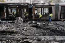  ?? ?? Debris is cleared from the burned-out transit system Friday in the aftermath of the violence that rocked the city center.