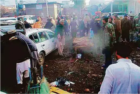  ?? Online ?? Security forces and residents gather at site of a bomb blast at a vegetable market in Parachinar city in Kurram tribal district in Pakistan. The militant group that claimed responsibi­lity said the attack is also to teach a lesson to Shiites for their...