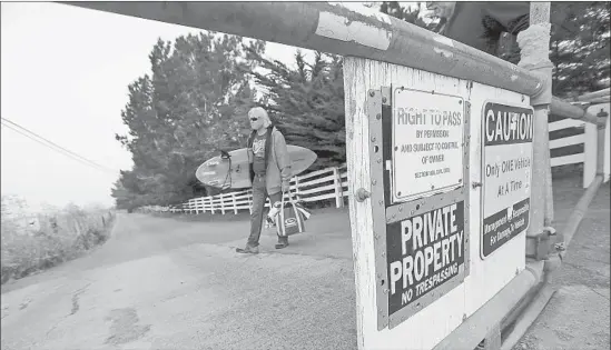  ?? Allen J. Schaben Los Angeles Times ?? MARK MASSARA, a lawyer for the Surfrider Foundation, which sued billionair­e Vinod Khosla over Martins Beach, passes a locked gate at the entrance in 2016.