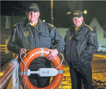  ??  ?? LIFE SAVERS: Gareth Norman, left, and William Brown of Coastwatch Tay with one of the replacemen­t life rings at Broughty Ferry harbour. Picture by Mhairi Edwards.