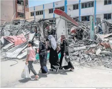  ?? MOHAMMED SABER / EFE ?? Unas palestinas pasan ante el edificio destruido del Ministerio del Interior de Hamas en Gaza.
