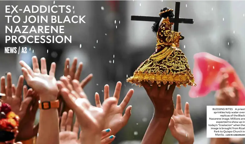  ?? —LEO M. SABANGAN ?? BLESSING RITES A priest sprinkles holy water over replicas of the Black Nazarene image. Millions are expected to show up in today’s “traslacion” when the image is brought from Rizal Park to Quiapo Church in Manila.