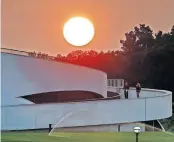  ?? [ERIC ALBRECHT/DISPATCH] ?? A couple ride scooters down a ramp at the National Veterans Memorial and Museum as the hazy sun sets on Tuesday.