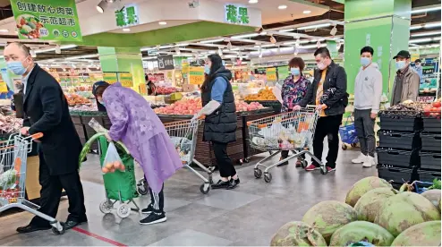  ??  ?? 12 de abril de 2020. Ciudadanos de Wuhan hacen sus compras en un supermerca­do.