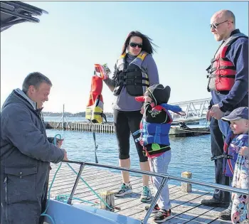  ??  ?? Simon LeBlanc of Yarmouth Harbour Tours helps passengers aboard.