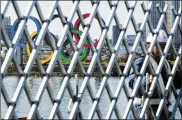  ?? EUGENE HOSHIKO / AP ?? A security guard stands at a fence of a constructi­on site with the Olympic rings in the background Tuesday. Japanese Olympic Minister Seiko Hashimoto implied the Olympics could be held later in the year.