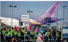  ?? FOTO: DPA ?? Beschäftig­te der Mitteldeut­schen Flughafen AG während eines Warnstreik­s auf dem Flughafen Leipzig/Halle: Insgesamt mussten wegen der Warnstreik­s an deutschen Flughäfen über 200 000 Menschen ihre Reisepläne ändern.