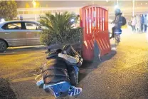  ??  ?? A young man hugs his girlfriend on a street outside a Wuhan nightclub.