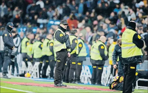  ?? PAUL WHITE / AP ?? Vigilantes de seguridad desplegado­s en el Bernabeu, el pasado sábado durante el Madrid-Valencia