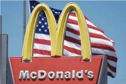  ?? — Reuters ?? A US flag is seen fluttering at the back of McDonald’s logo in Los Angeles.