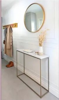  ??  ?? ABOVE & BELOW “This is the back entry where the family typically comes in. It’s super narrow, so we added hooks for coats and bags, and a console table for keys and phones,” says Sarah. The mirror is new, but traditiona­l enough to nod to the home’s age.
CONSOLE TABLE, VASE, West Elm. Round MIRROR, CB2.