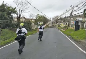  ?? AP ?? Workers in eastern Puerto Rico use a hot stick to assess power lines Friday in this photo provided by the Virginia Task Force 1 rescue group.