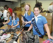  ??  ?? Helping with donated shoes are Dannika Makara and Alyssa Kantymir, with First Black Mountain Brownies, and Cali Kantymir and Rhea McNair, with First Black Mountain Girl Guides.