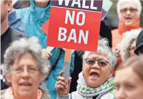  ?? TED S. WARREN, AP ?? Protesters wave signs and chant during a demonstrat­ion against President Trump’s revised travel ban, on May 15 outside a federal courthouse in Seattle.