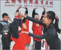  ?? PHOTOS BY HU MEIDONG / CHINA DAILY ?? From left: A teacher gives a dance lesson to students at Sanming Special Education School in Sanming, Fujian province. Principal Li Qin introduces the school to visitors.