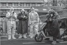  ?? Kevin Frayer/getty Images ?? Chinese epidemic control workers stand Tuesday in an area where some communitie­s are under lockdown in Beijing.