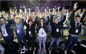  ?? ELAINE THOMPSON — THE ASSOCIATED PRESS ?? Participan­ts attending the keynote address at Microsoft’s Build, the company’s annual conference for software developers, are led in standing and stretching mid-way through the morning event Monday in Seattle.