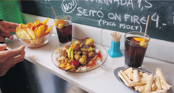  ?? RICK STEVES ?? Standing at a bar with a sampler of tapas and chalkboard specials on the wall is a quintessen­tial experience in Spain.