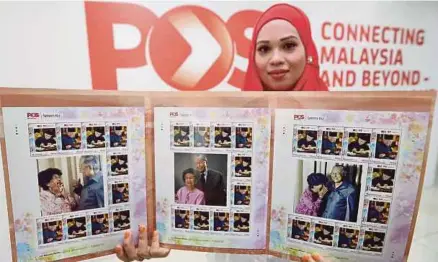  ?? [FOTO ZULFADHLI ZULKIFLI/BH] ?? Kakitangan Pos Malaysia, Nurul Nadiana Mohd Tahir tahun ke-93 Dr Mahathir, di Kuala Lumpur, semalam. memegang Folder Set Setem Ku sempena ulang