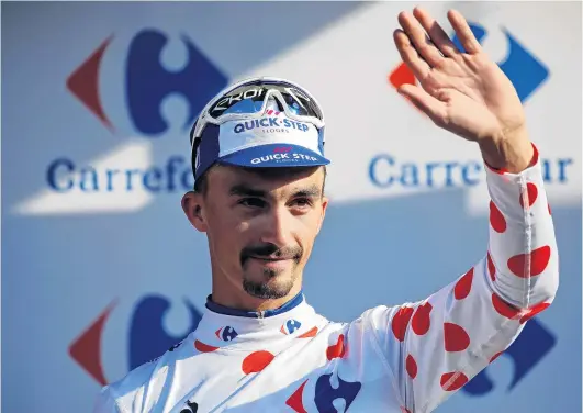  ?? PHOTO: REUTERS ?? A perfect 10 . . . French rider Julian Alaphilipp­e celebrates on the podium yesterday after winning the 10th stage of the Tour de France and also claiming the king of the mountains polkadot jersey.