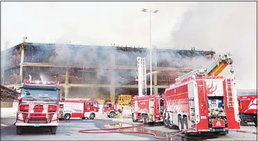  ?? KUNA photo ?? Firemen in bid to put out a fire that broke out in a building under constructi­on in South Surra area.