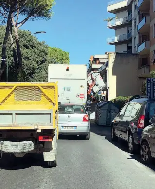  ??  ?? Ore 14,15 di giovedì, un compattato­re svuota un cassonetto e blocca il traffico in via del Campofiore