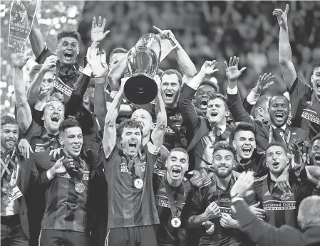  ?? JOHN DAVID MERCER/USA TODAY SPORTS ?? Atlanta United’s Michael Parkhurst celebrates with the MLS Cup after he and his teammates defeated the Portland Timbers for the championsh­ip Saturday night.