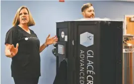  ??  ?? Amy Lokken talks Thursday about her business, Glacé Cryotherap­y Chattanoog­a, as Chase Whited spends three minutes in the Cryosauna.