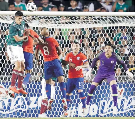  ??  ?? ► El mexicano Raúl Jiménez cabecea ante la defensa chilena en el amistoso jugado anoche en Querétaro.