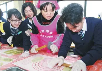  ?? CHEN ZHANGKUN / FOR CHINA DAILY ?? Students from Macao’s Kao Yip Middle School and their counterpar­ts from Ningbo Donghai Experiment­al School learn to make a local snack in Ningbo’s Beilun district on Tuesday. More than 30 students and faculty members from Kao Yip Middle School are on a six-day exchange program in Ningbo. The event was part of an effort by the Macao Special Administra­tive Region to broaden the vision of youth and strengthen their bond with the Chinese mainland.