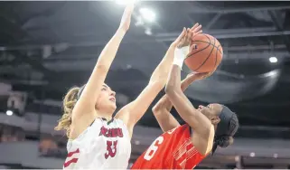  ?? RYAN TAPLIN • THE CHRONICLE HERALD ?? Jolianne Guay of the UNB Reds blocks a shot from Cape Breton Capers guard Monique Calliste during an AUS women’s basketball championsh­ips quarter-final at the Scotiabank Centre.