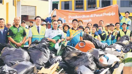  ?? — Photo by Galileo Petingi ?? Hilmy (front, second right) and ASEZ WAO Kuching head manager Daniel Leem Jalang, join other officials in a group photo with the volunteers of the clean-up drive at Sungai Maong Wet Market in Kuching.