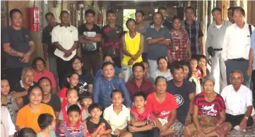  ??  ?? Huang (second row from front, fourth right) joins the villagers of Rumah Jawi in a photo-call on their veranda.