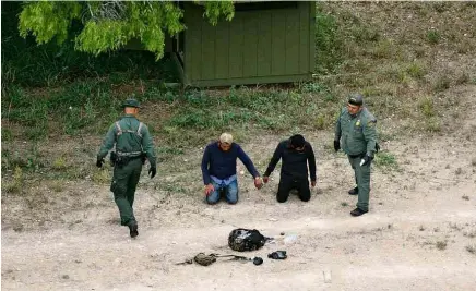  ?? Loren Elliott/Reuters ?? Agentes da patrulha da fronteira prendem dois imigrantes que tentaram cruzar fronteira no rio Grande, no Texas