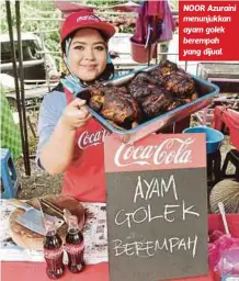  ??  ?? NOOR Azuraini menunjukka­n ayam golek berempah yang dijual.