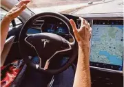  ?? David Paul Morris / Bloomberg file ?? A reporter test drives a Tesla Model S car equipped with Autopilot. New rules for self-driving cars are being written by regulators.