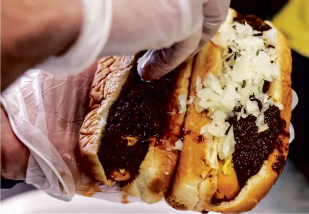  ?? MArK stocKWell for the boston Globe ?? Classic hot wieners “all the way” — with chili, mustard, chopped onions, and celery salt — at Baba’s Original New York System in Providence.