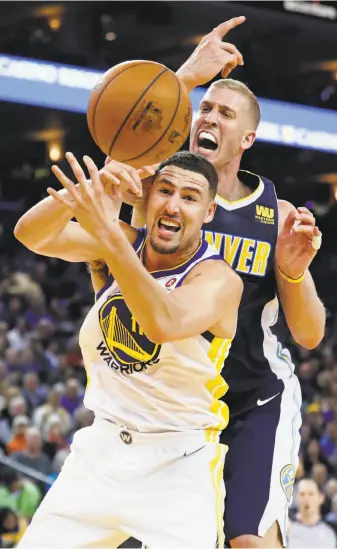  ?? Scott Strazzante / The Chronicle ?? The Warriors’ Klay Thompson and the Nuggets’ Mason Plumlee vie for a rebound in the third quarter. Thompson finished with five boards, three fewer than Plumlee, a 6-foot-11 center.