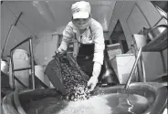  ?? LI HANCHI / XINHUA ?? A worker pours river snails — a key ingredient in making local specialty luosifen — into water to clean them at a workshop in Liuzhou, Guangxi Zhuang autonomous region, in September.